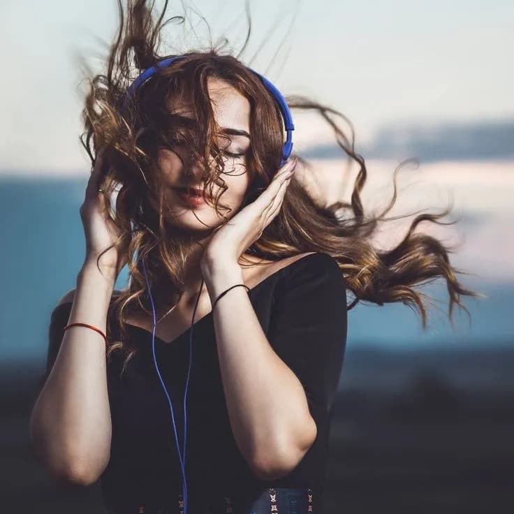 Woman with headphones and hair blowing in the wind
